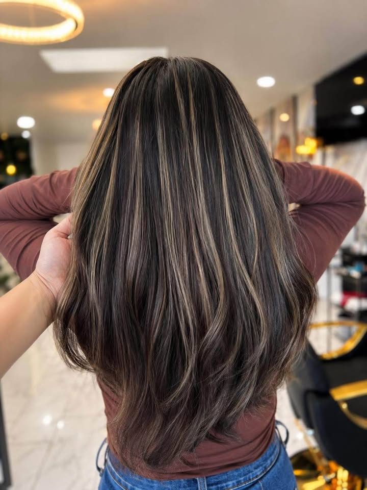 Subtle ash highlights woven through dark brunette hair