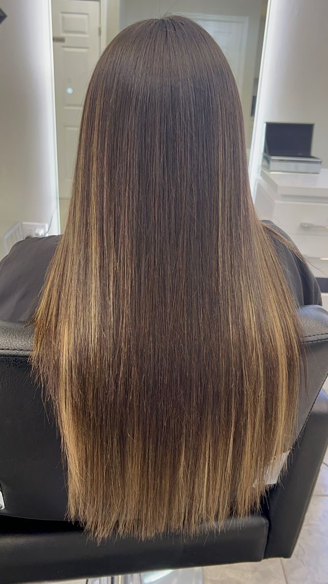 Dark roots melting into blonde balayage waves